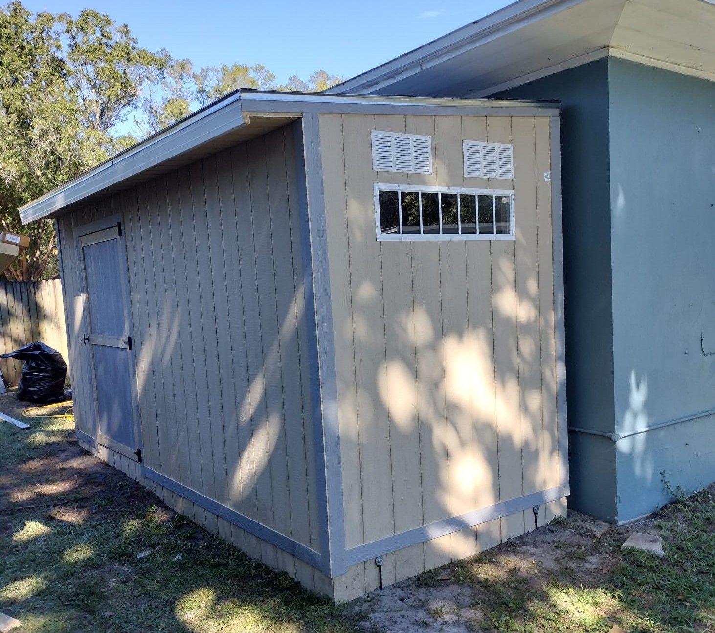 A small shed with a window on the side of a house