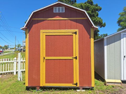 A tan and gray shed with a window on the side