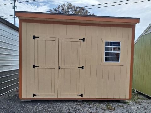 A small wooden shed with two doors and a window