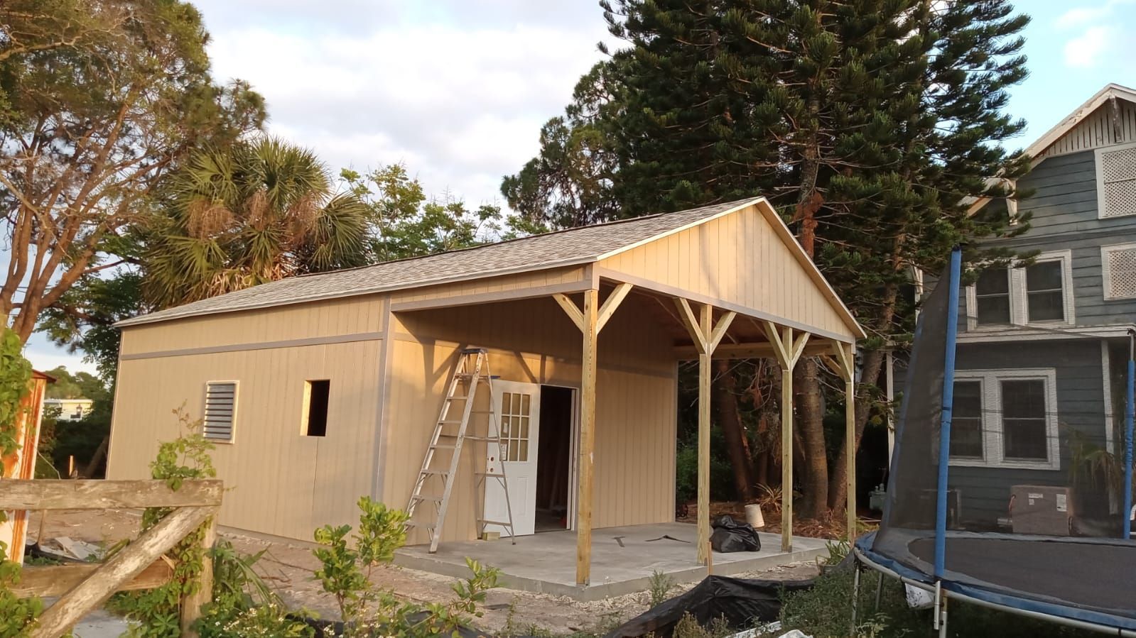 A small house with a trampoline in front of it is being built.