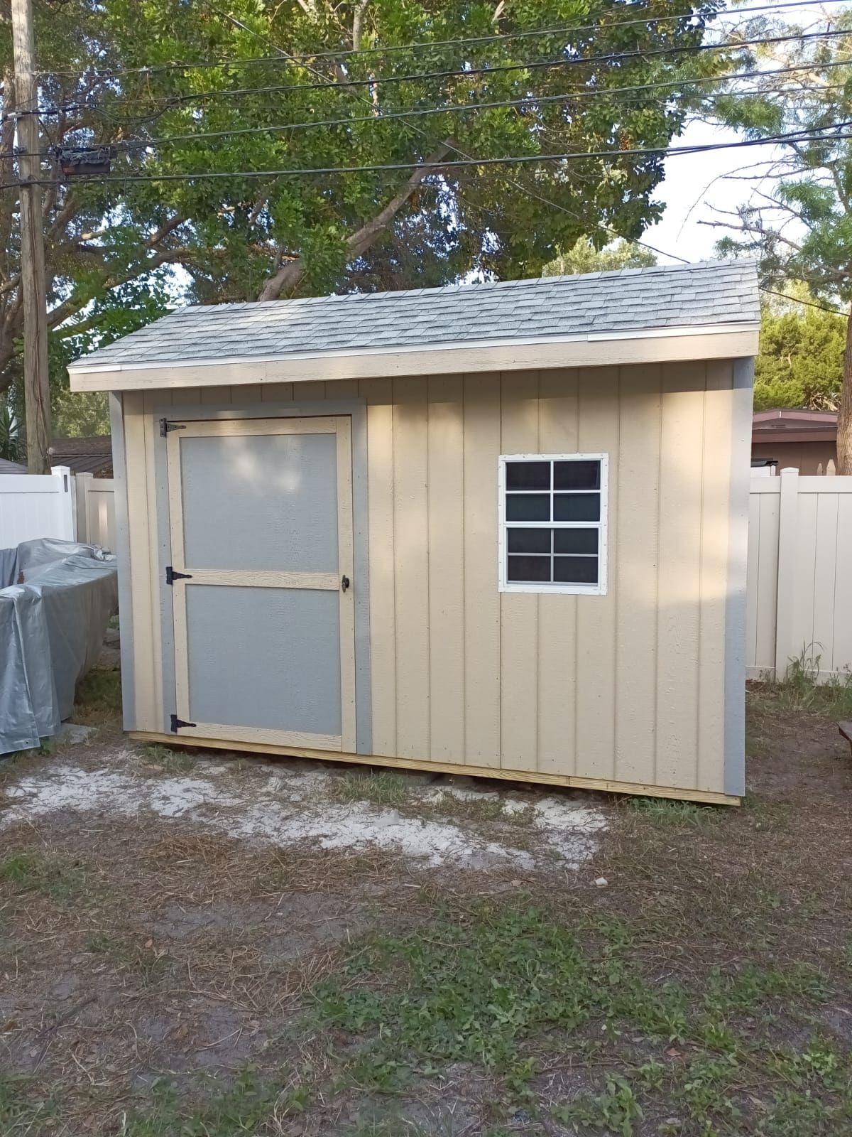 A small shed with a window in the backyard.