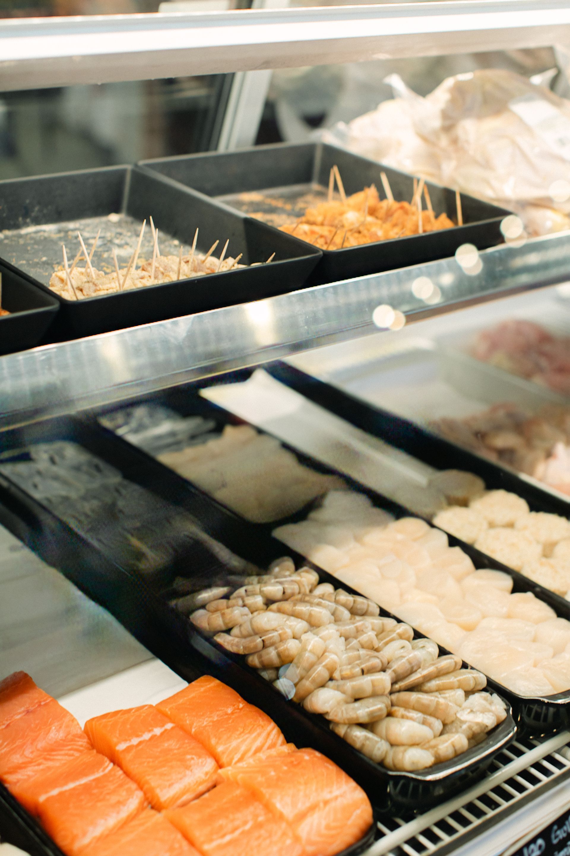 Assorted sushi rolls and ingredients in a restaurant buffet display case