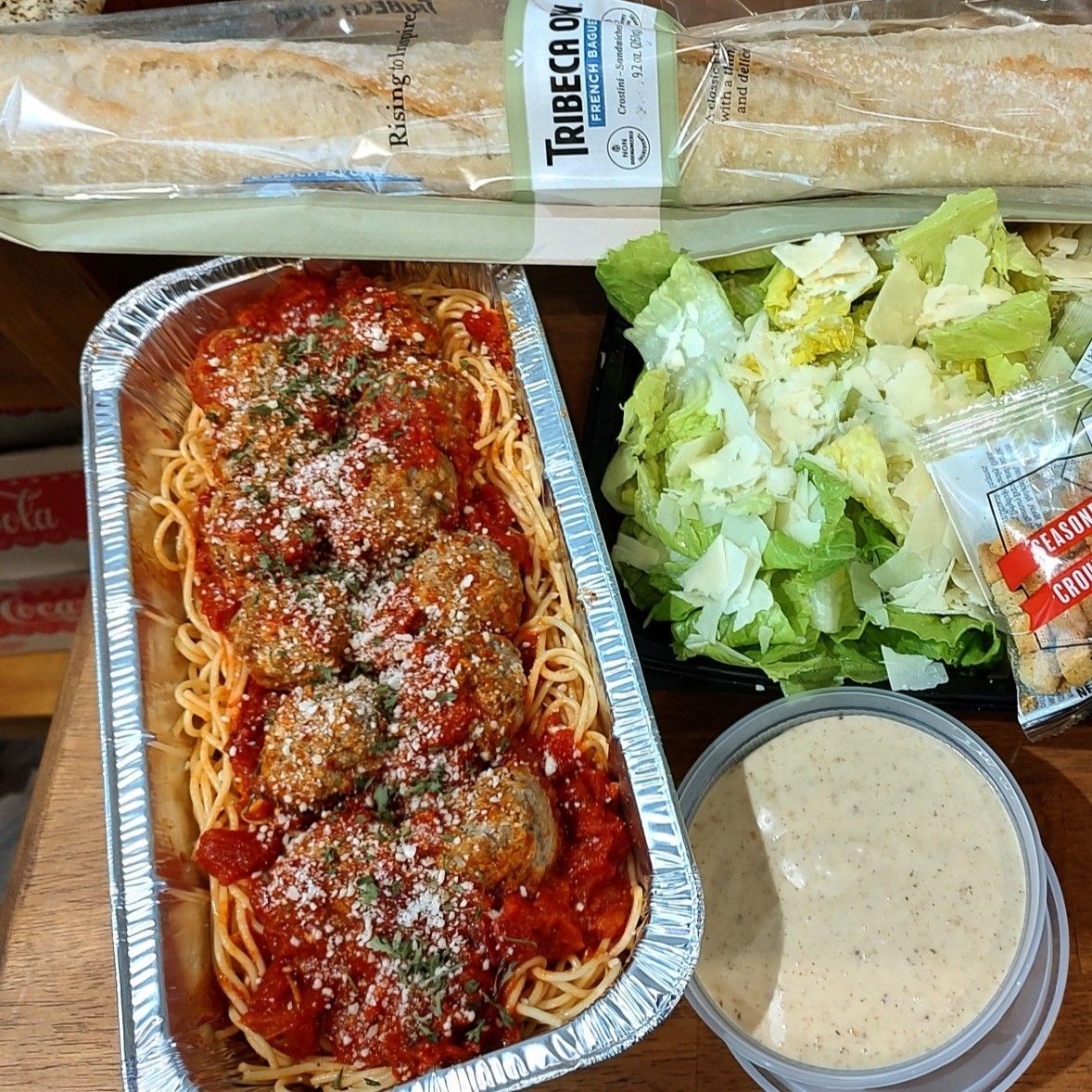 Takeout meal with spaghetti marinara, salad, breadstick, and a side of creamy dressing