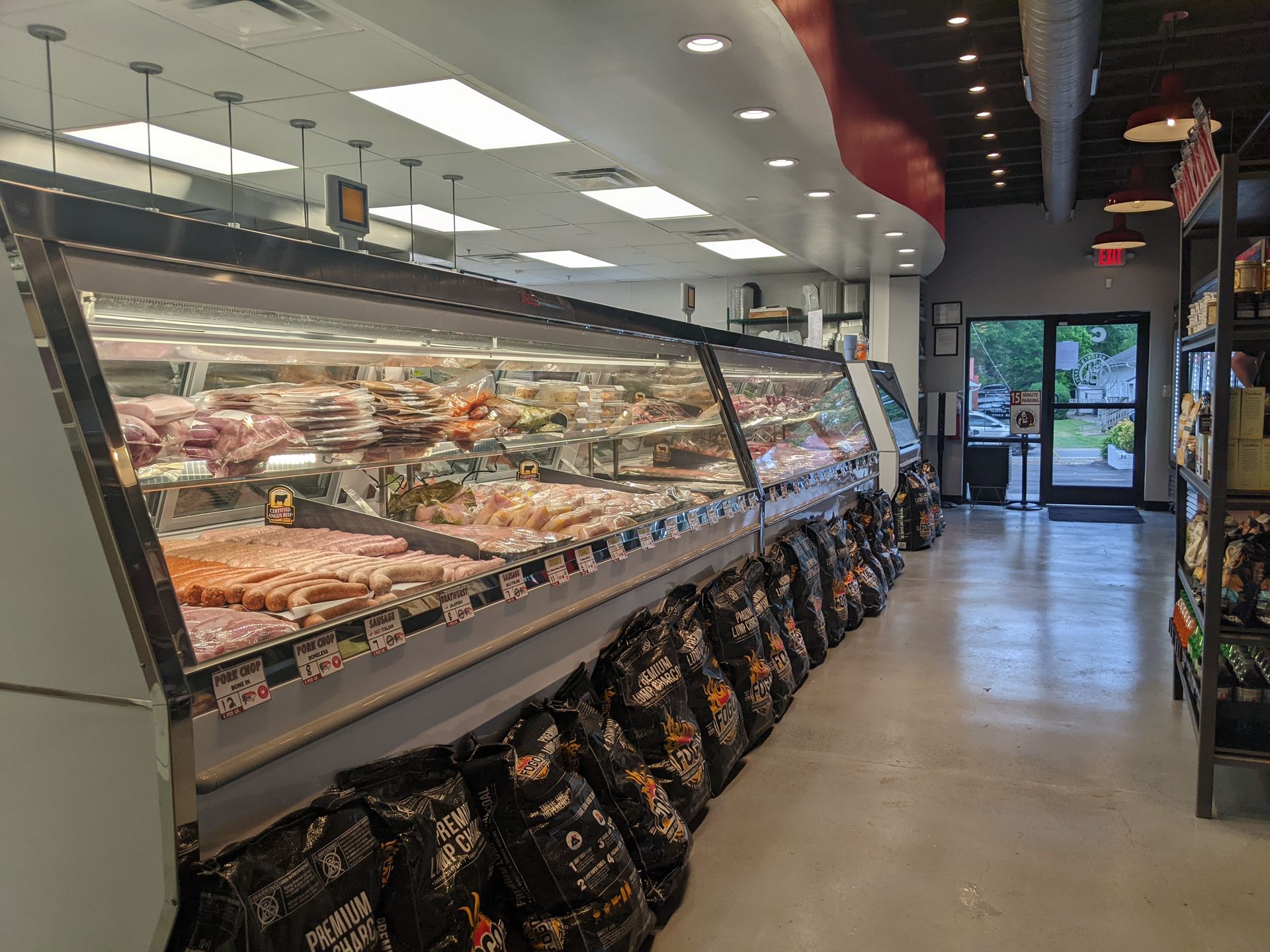 Grocery store deli counter with glass display cases and packaged items along the aisle.