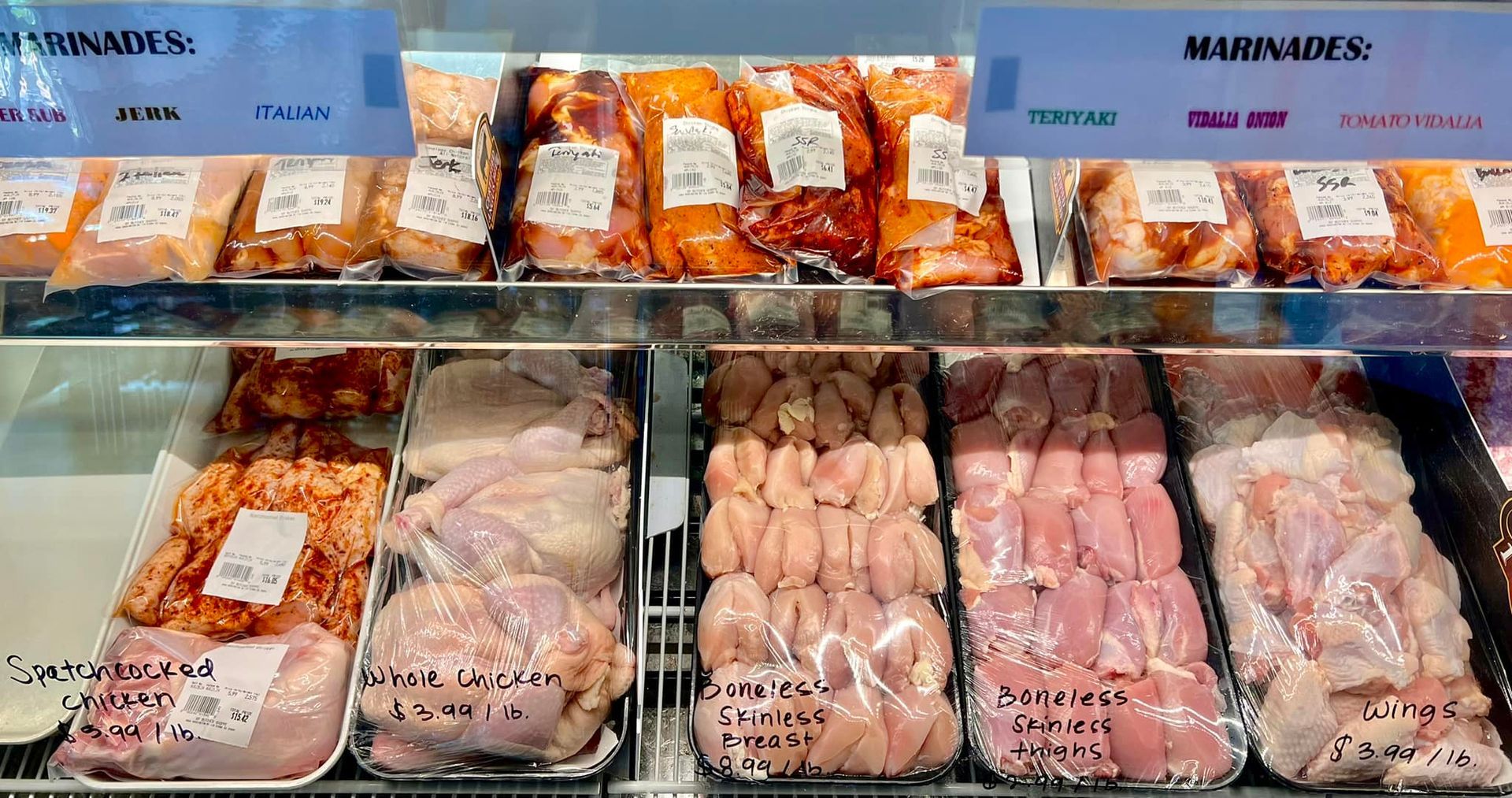 A display case of marinated chicken, labeled 