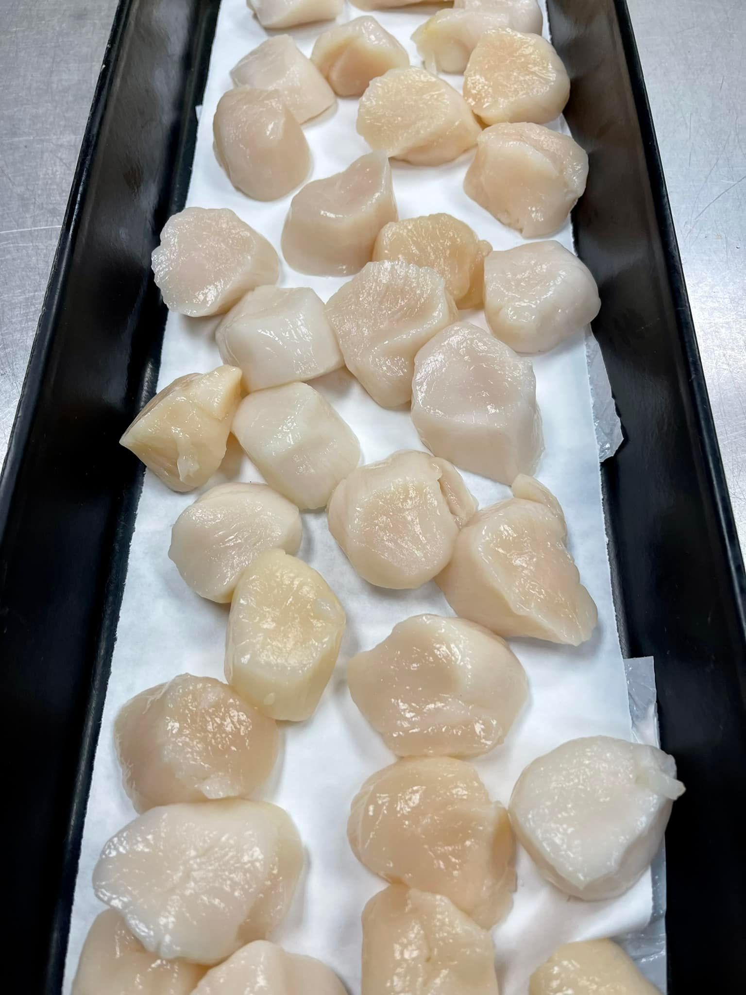 Scallops on a black tray