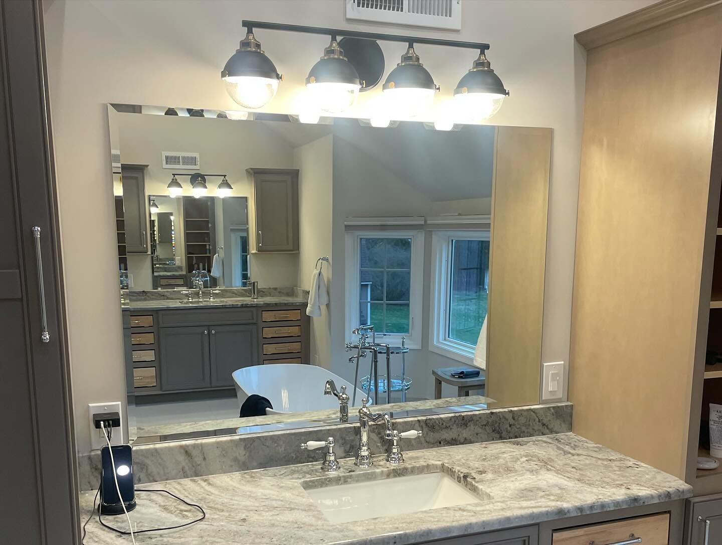 A bathroom with a sink and a large mirror.