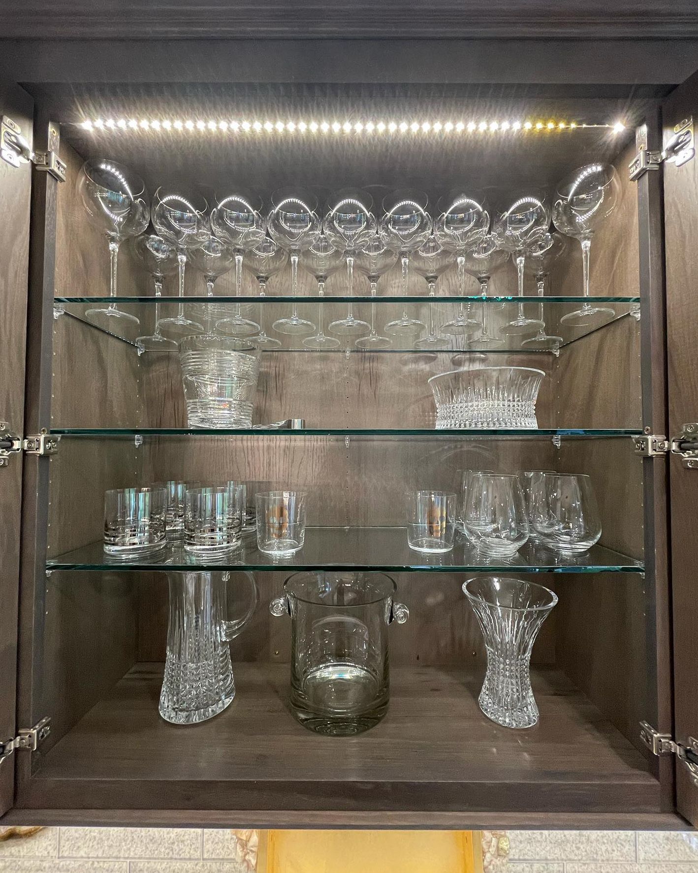 A display case filled with glasses, vases, and pitchers.