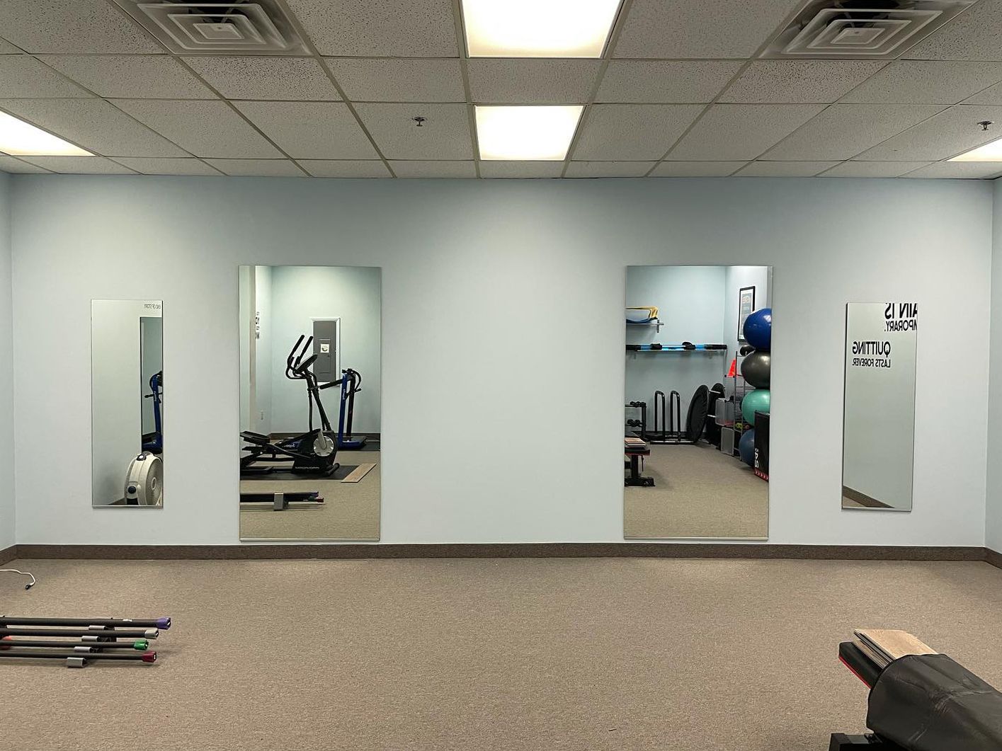 A gym with a lot of mirrors on the wall