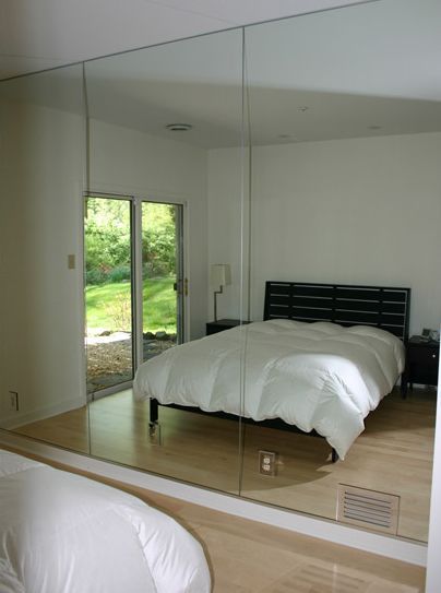 A bedroom with a large mirror