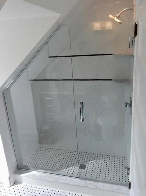 A bathroom with a glass shower door and a shower head.