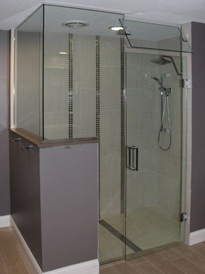 A shower stall with a glass door and a shower head in a bathroom.