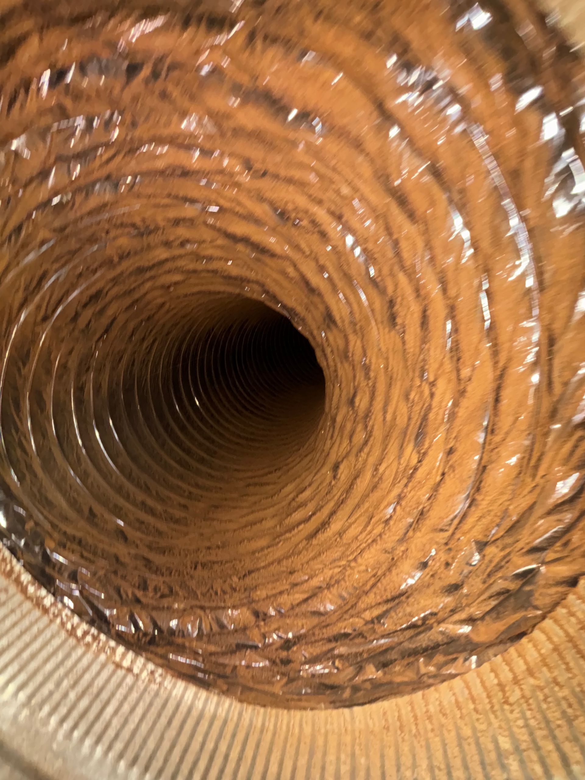 Close-up view down a rusty, corrugated metal pipe interior