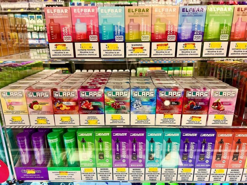 A shelf filled with boxes of e-cigarettes in a store.