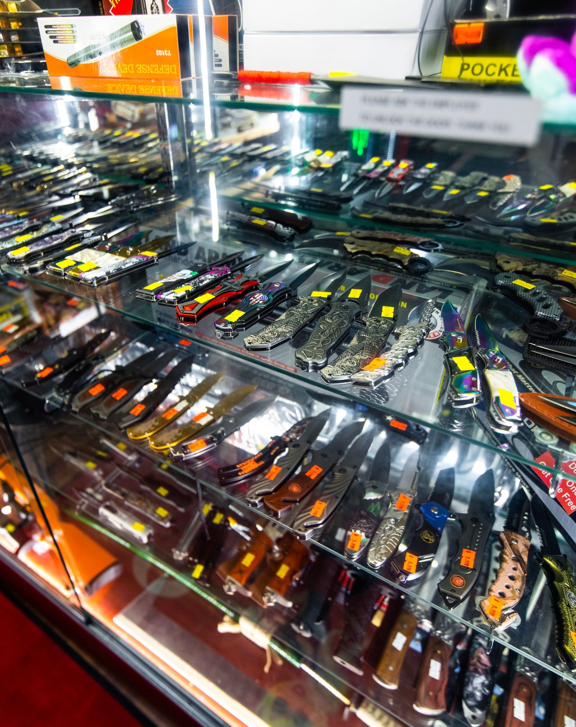 A display case filled with lots of pocket knives