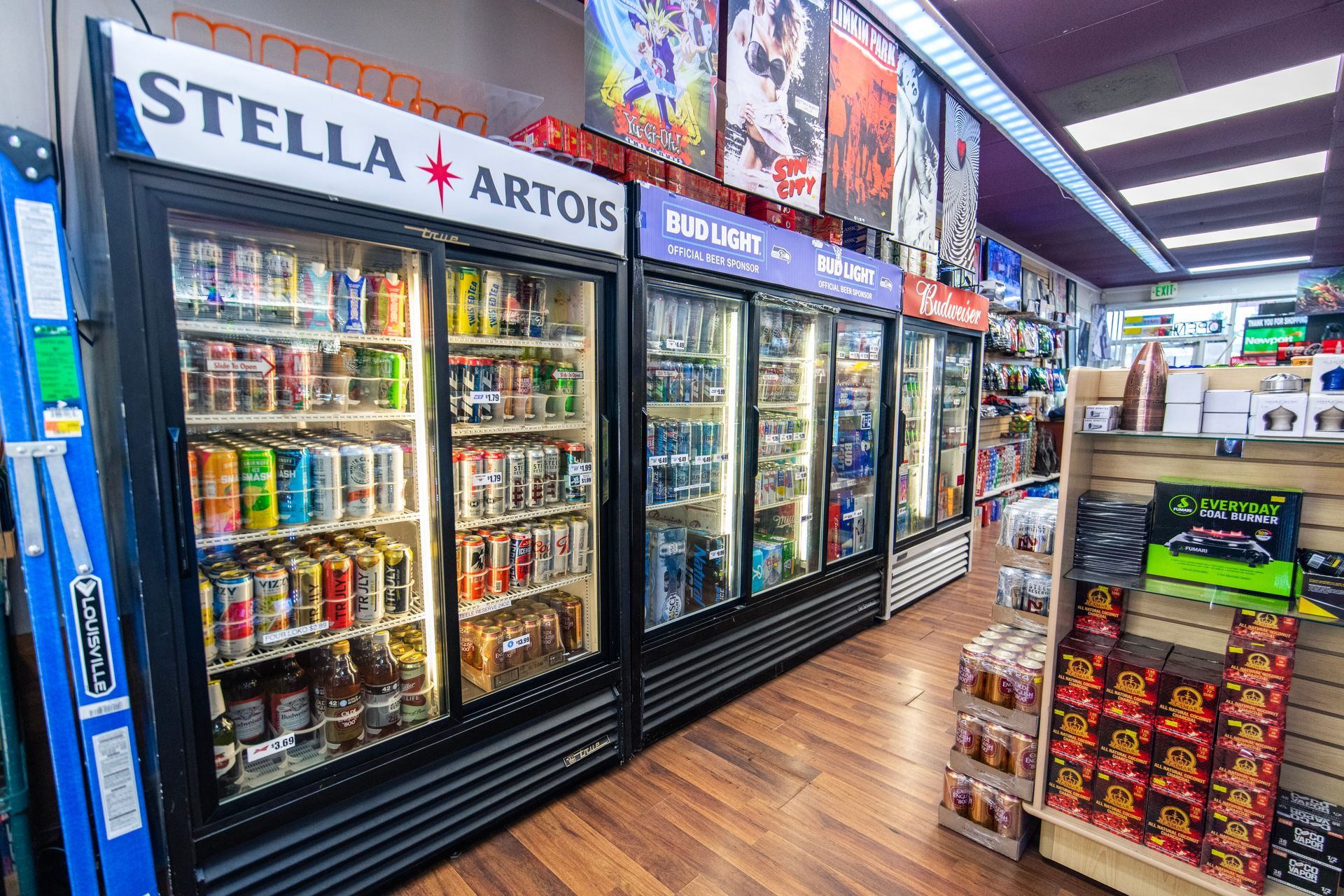 A row of refrigerators filled with beer and soda in a store.