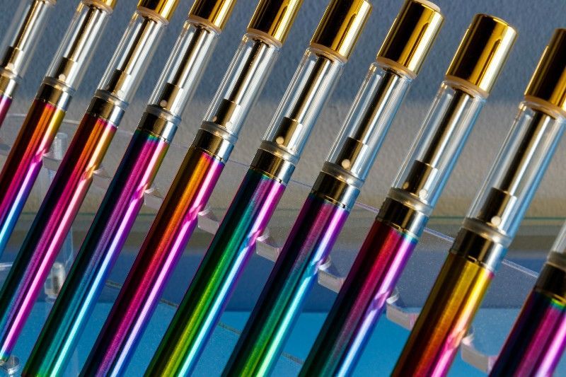 A bunch of colorful pens are lined up in a row