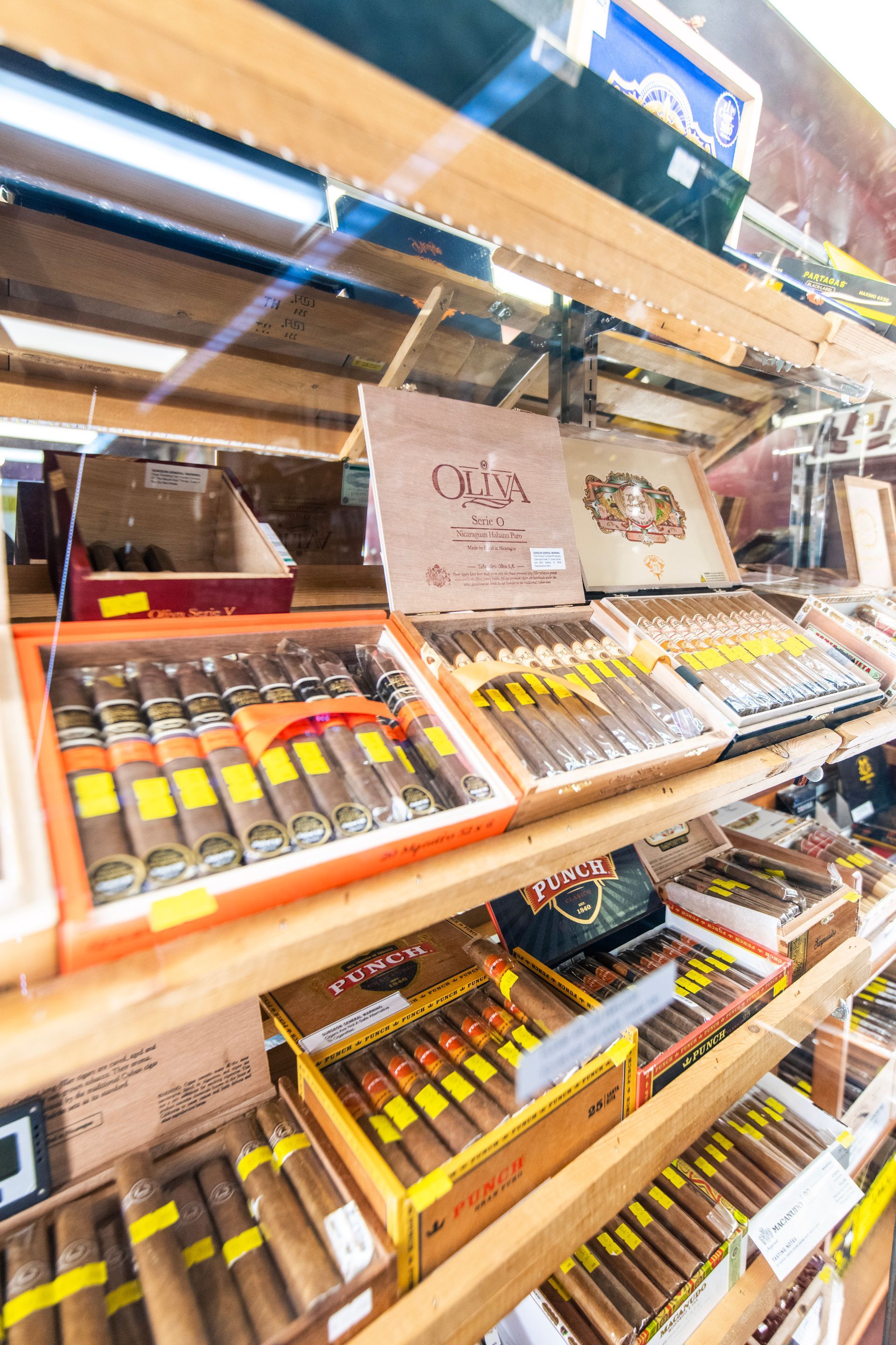 A shelf filled with boxes of cigars in a store.