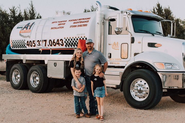 A family is standing in front of a large white truck.