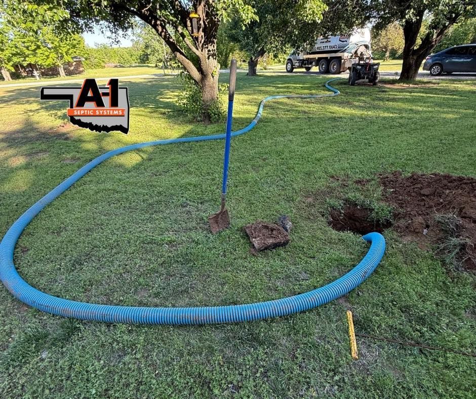 A blue hose is connected to a hole in the ground.