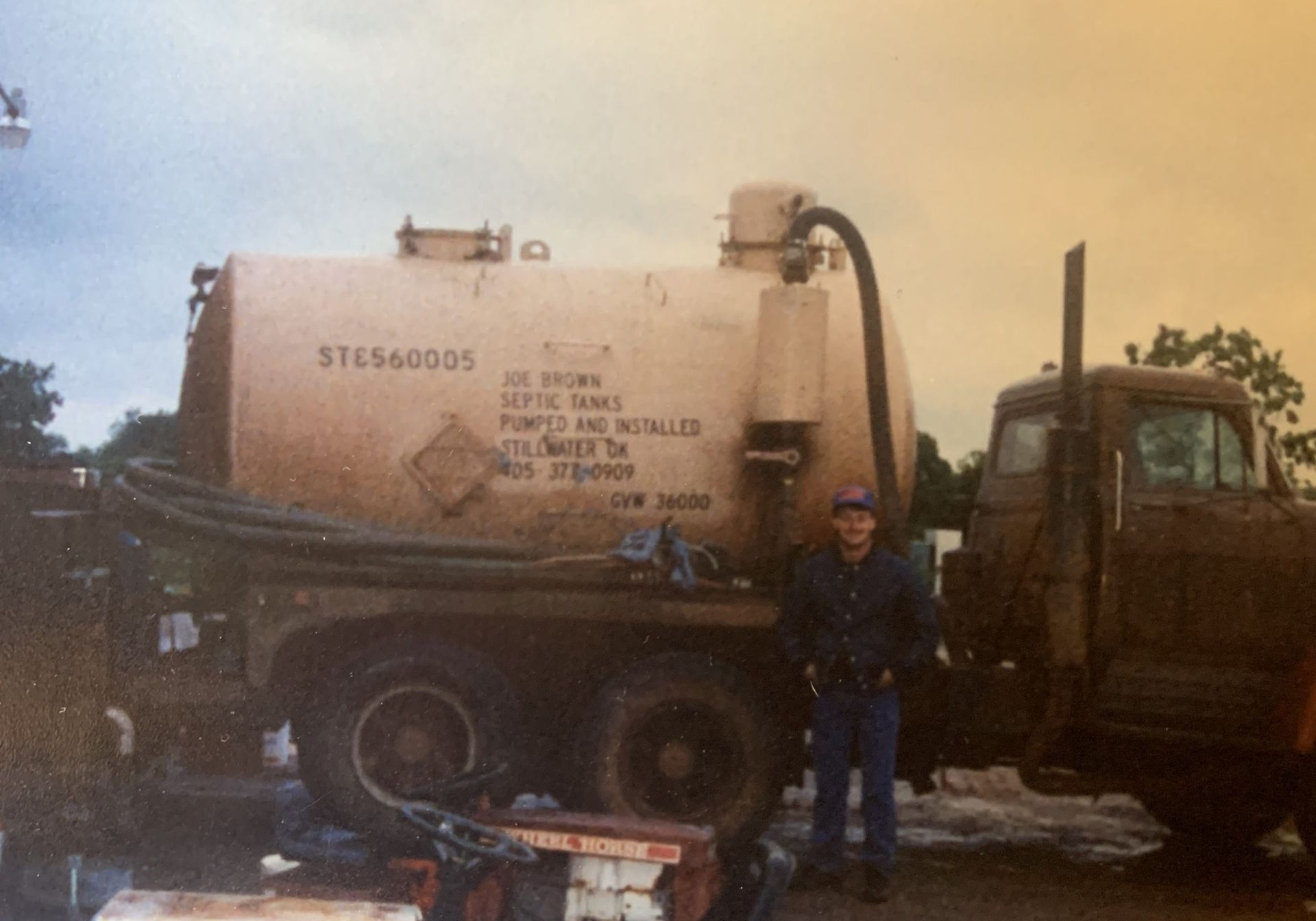 A man is standing in front of a truck that says ste660005