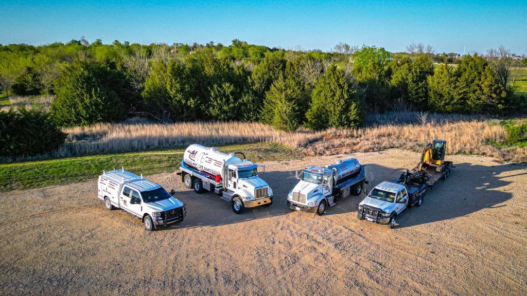 A group of trucks are parked next to each other in a dirt field.