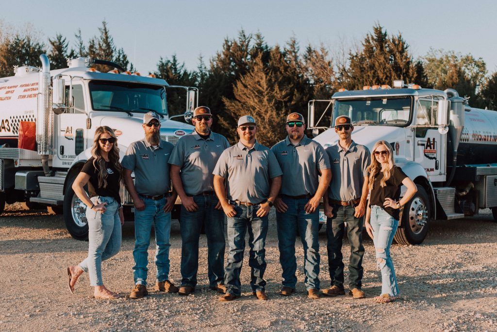 A group of people are posing for a picture in front of trucks.