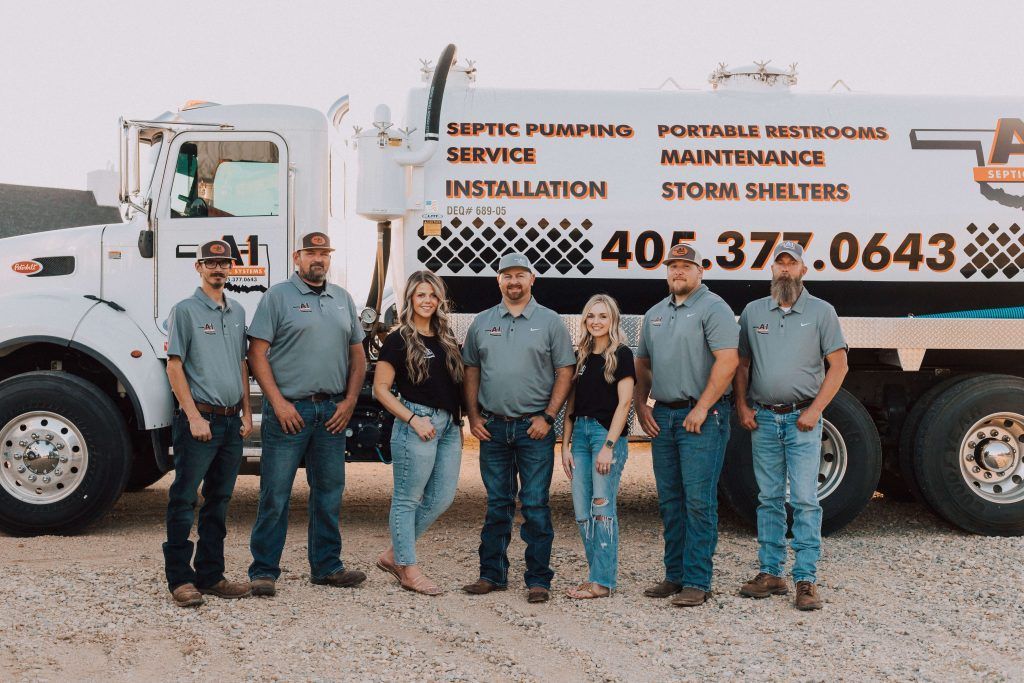 A group of people standing in front of a septic pumping truck.