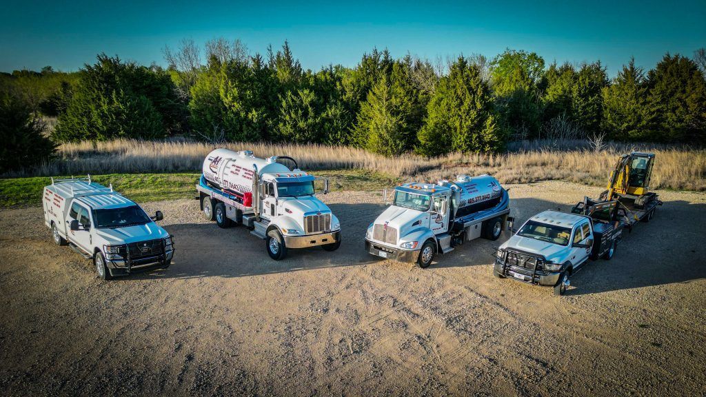 A group of trucks are parked next to each other in a dirt field.