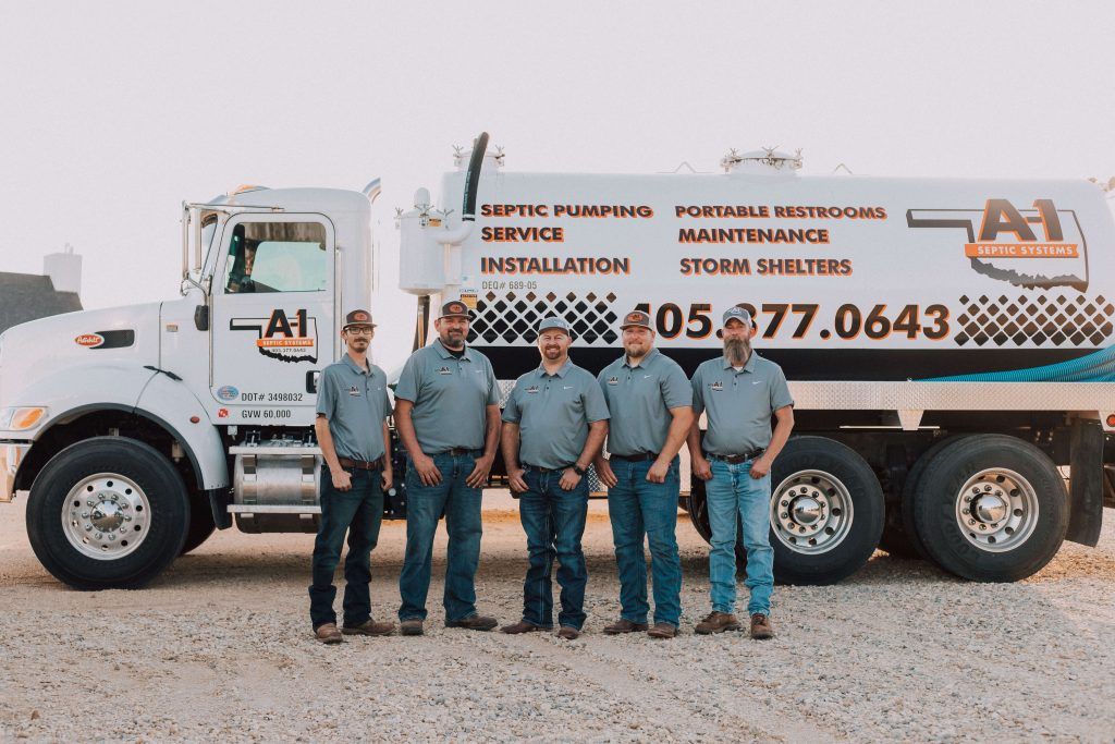 A group of men are standing in front of a large white truck.