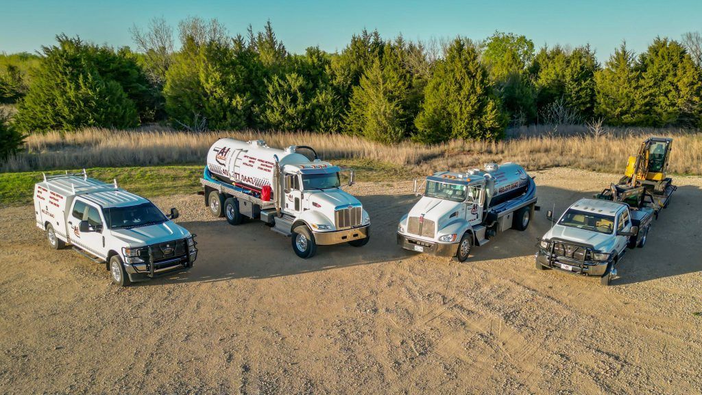 A group of trucks are parked next to each other in a dirt field.