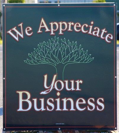 A sign that says  '' we appreciate your business '' with a tree on it.