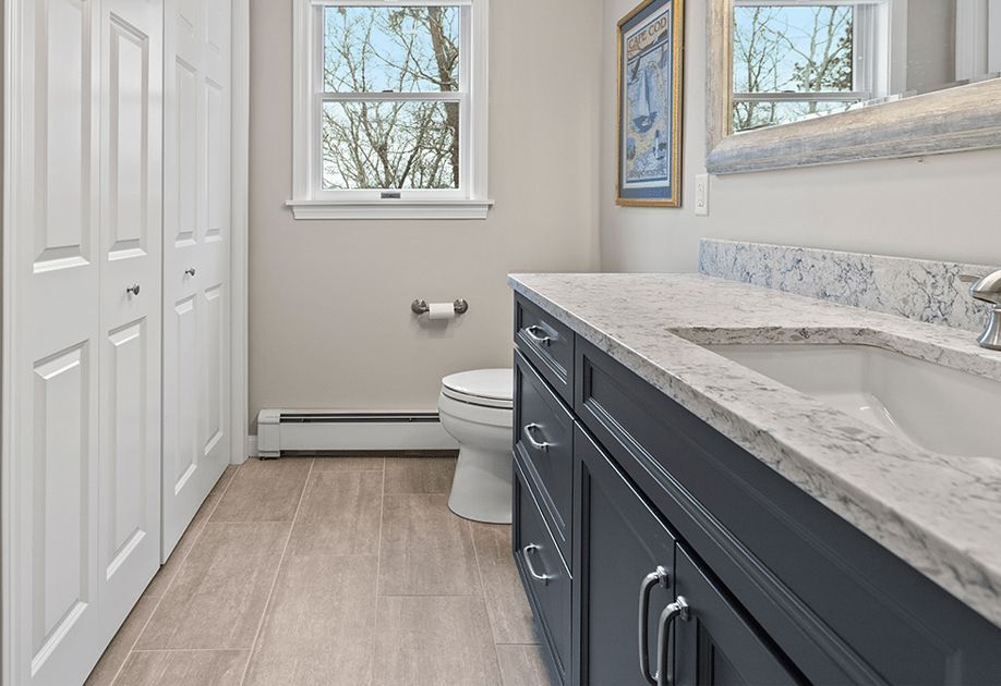 A bathroom with a toilet , sink and mirror.
