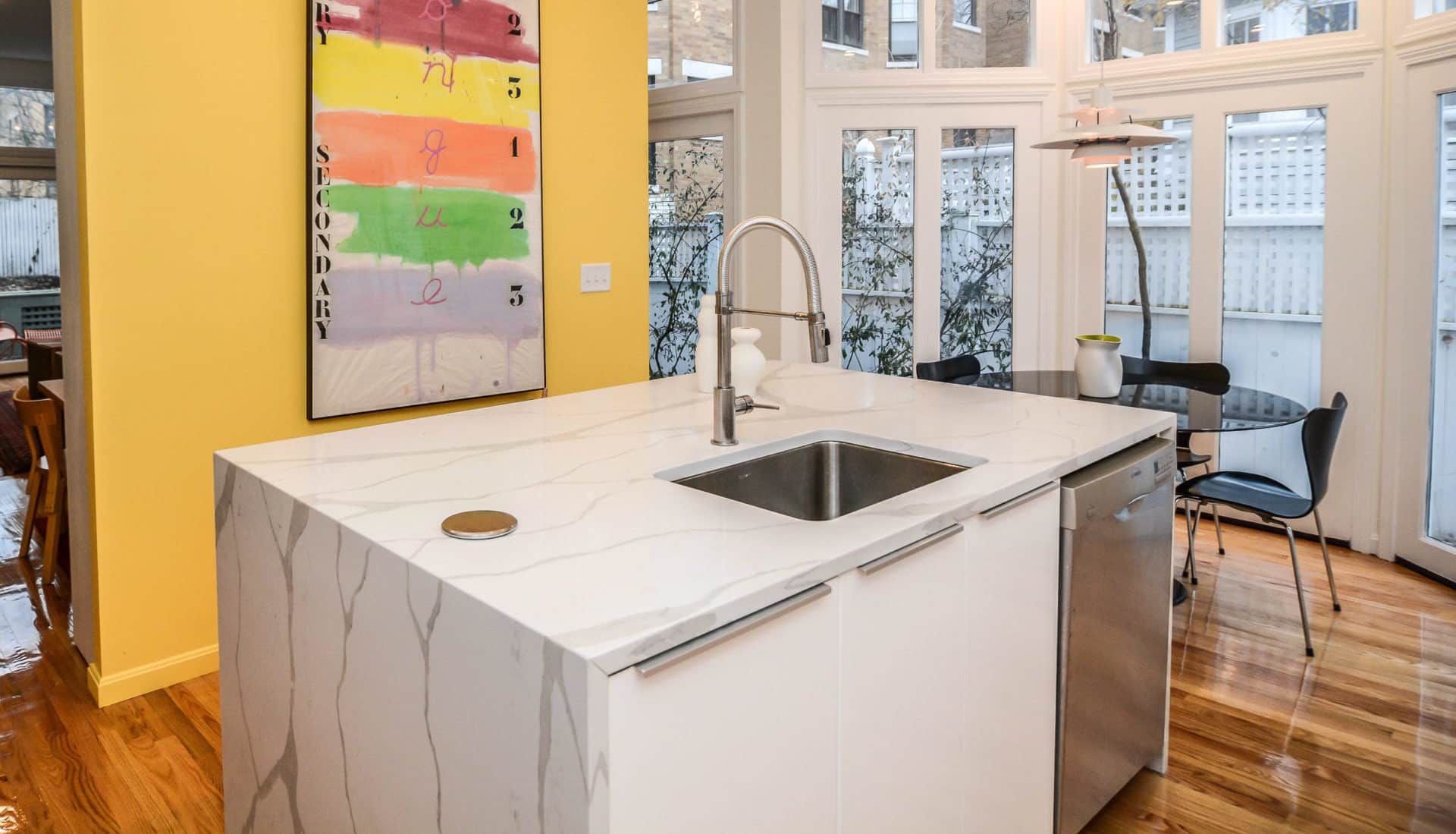 A kitchen with a large island and a sink.