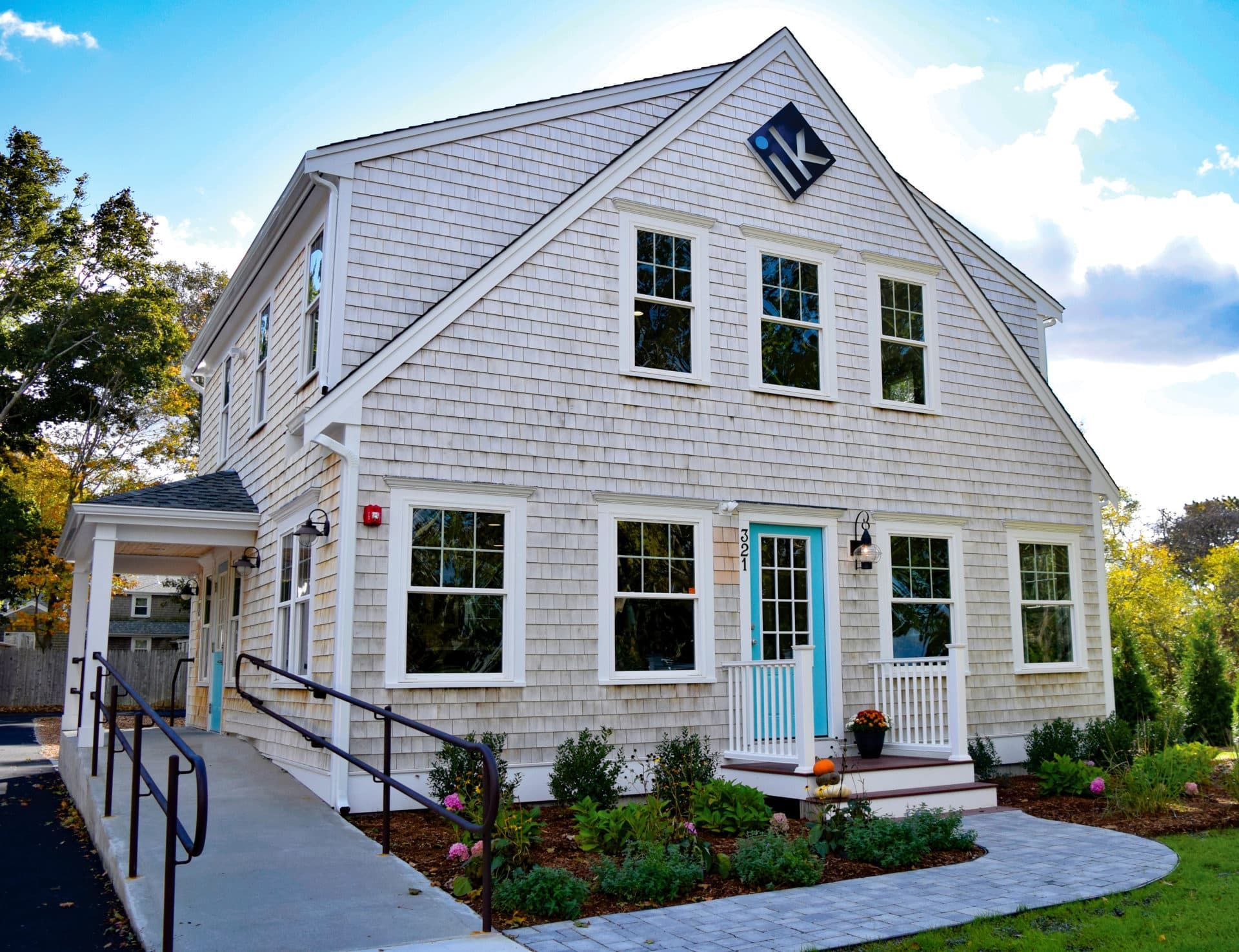 A white house with a blue door and a wheelchair ramp