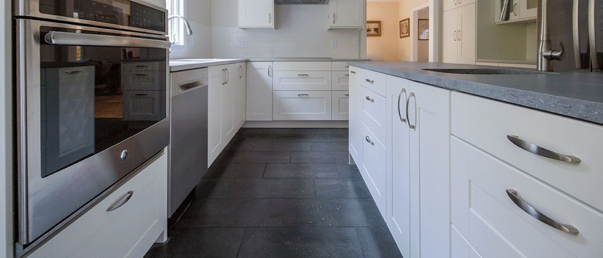 A kitchen with white cabinets and stainless steel appliances.