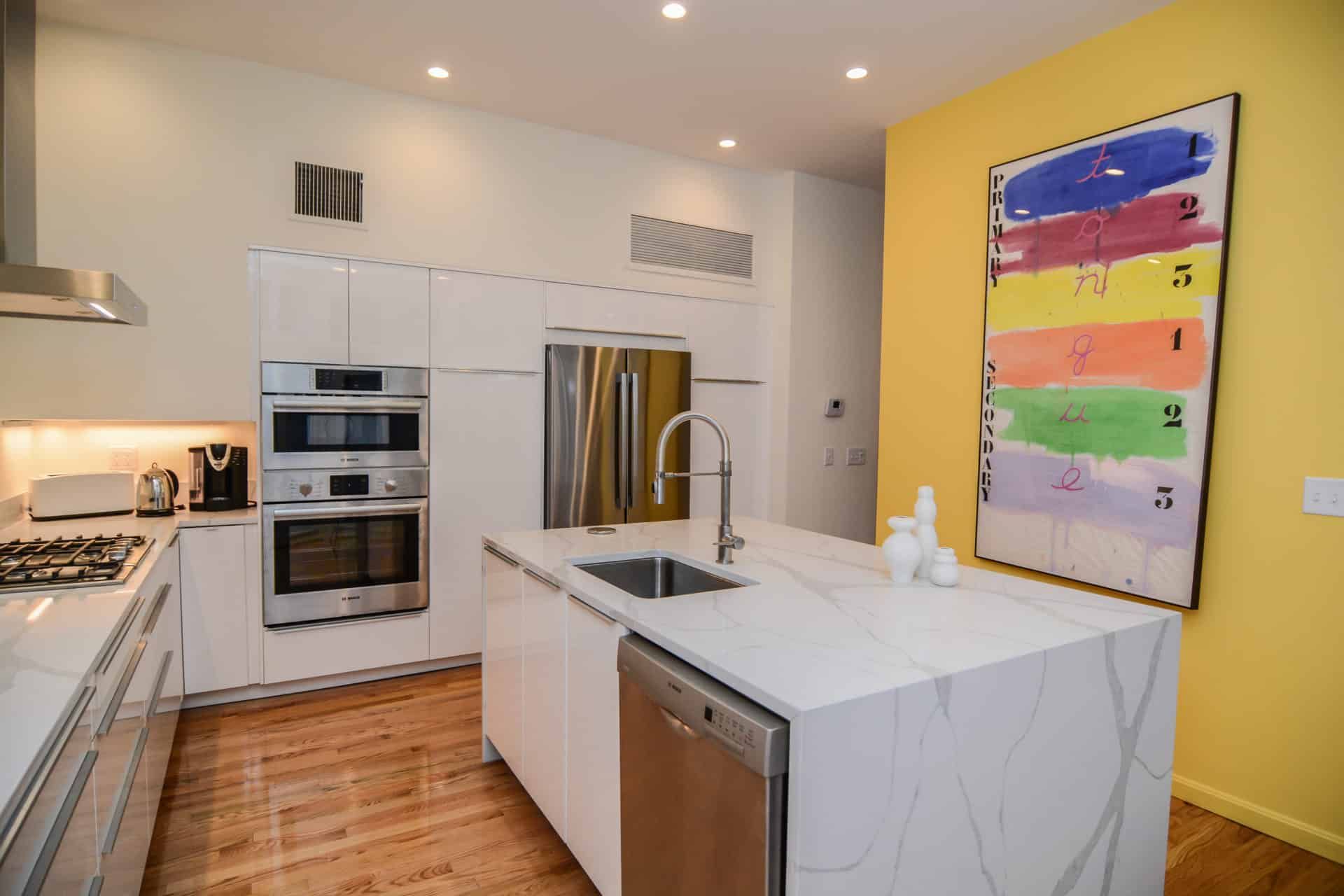 A kitchen with a large island and a painting on the wall.