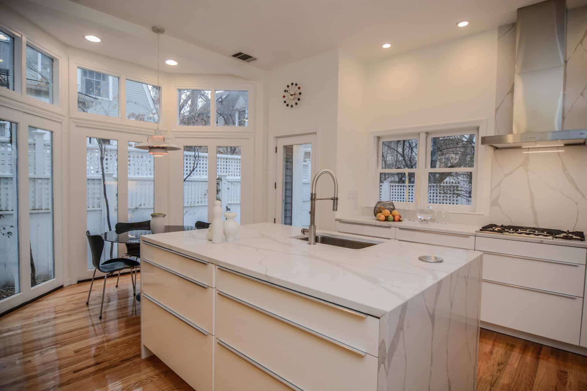 A kitchen with white cabinets and a large island in the middle.