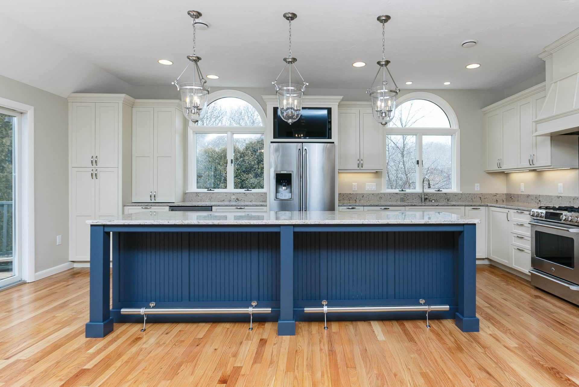 A kitchen with a blue island and white cabinets