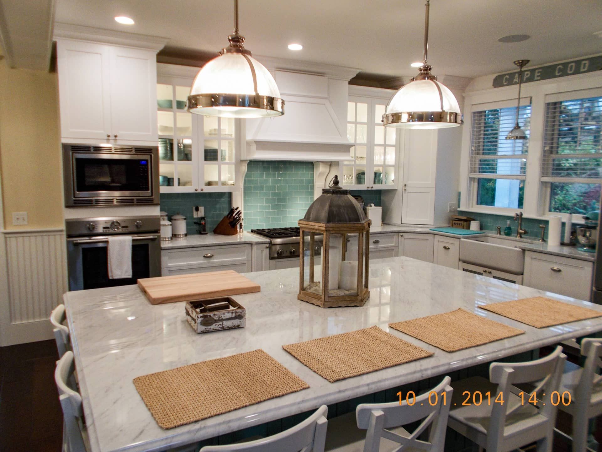 A kitchen with white cabinets and a large island