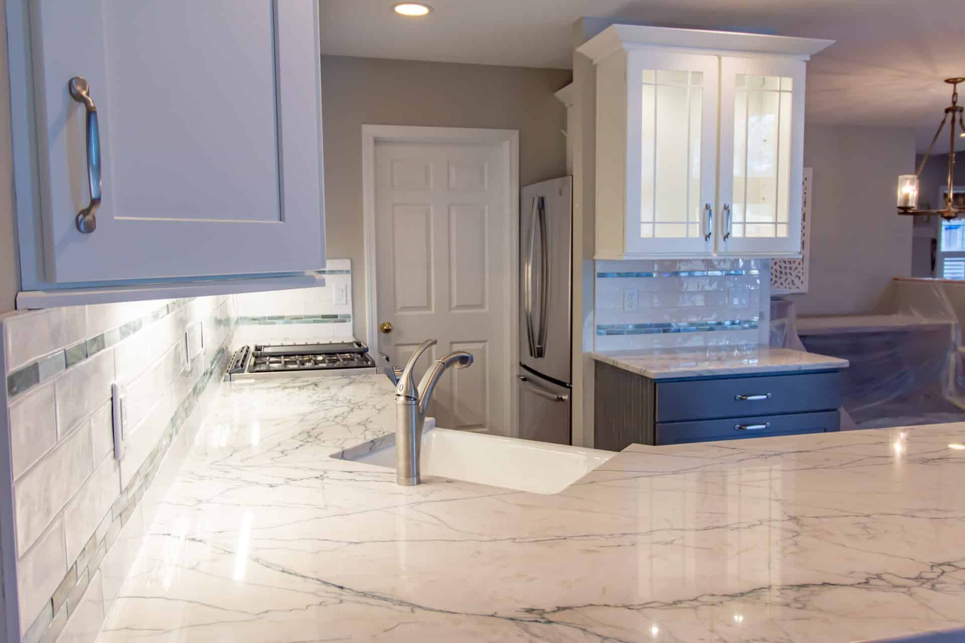 A kitchen with a sink, stove, refrigerator and cabinets.