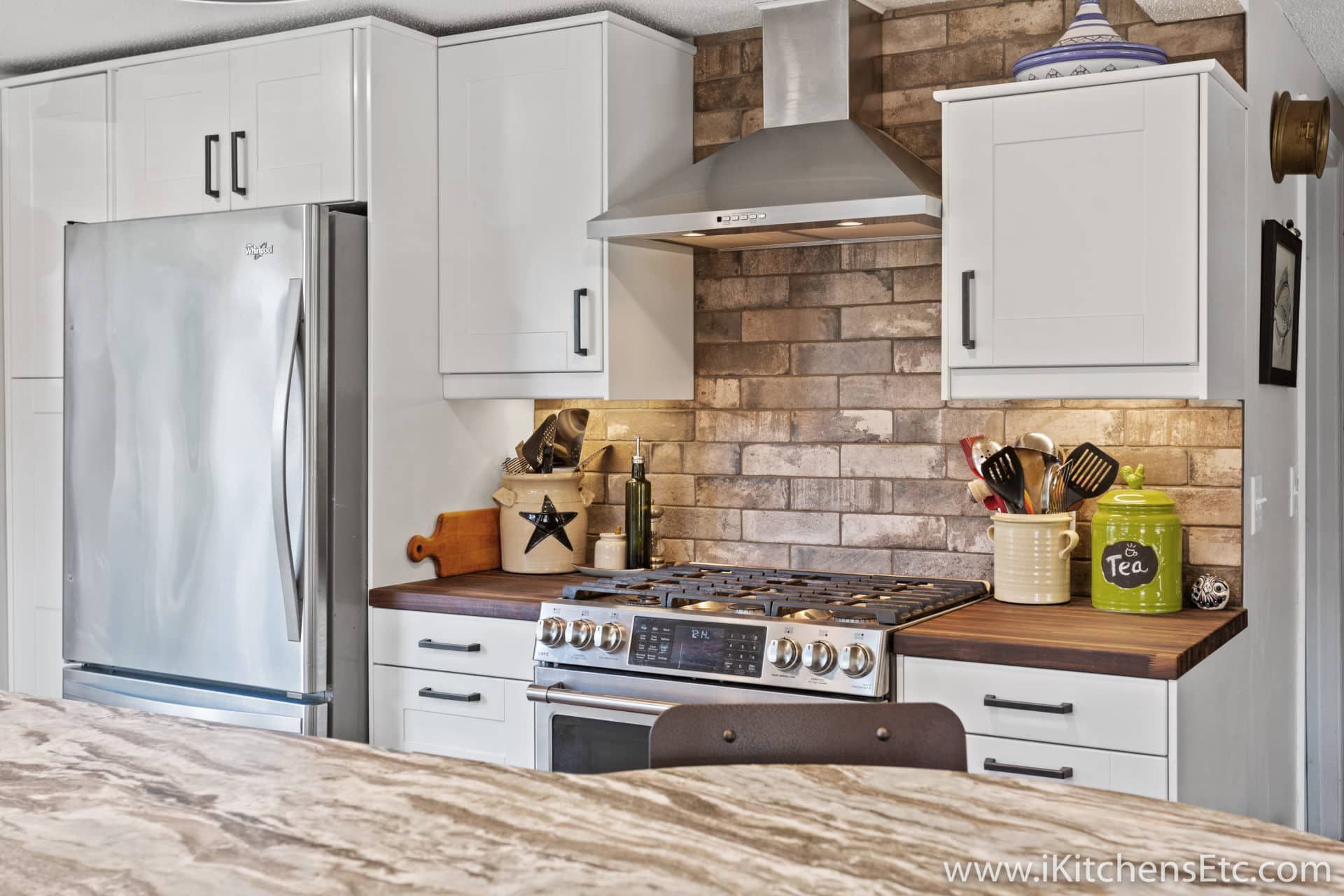 A kitchen with white cabinets and stainless steel appliances