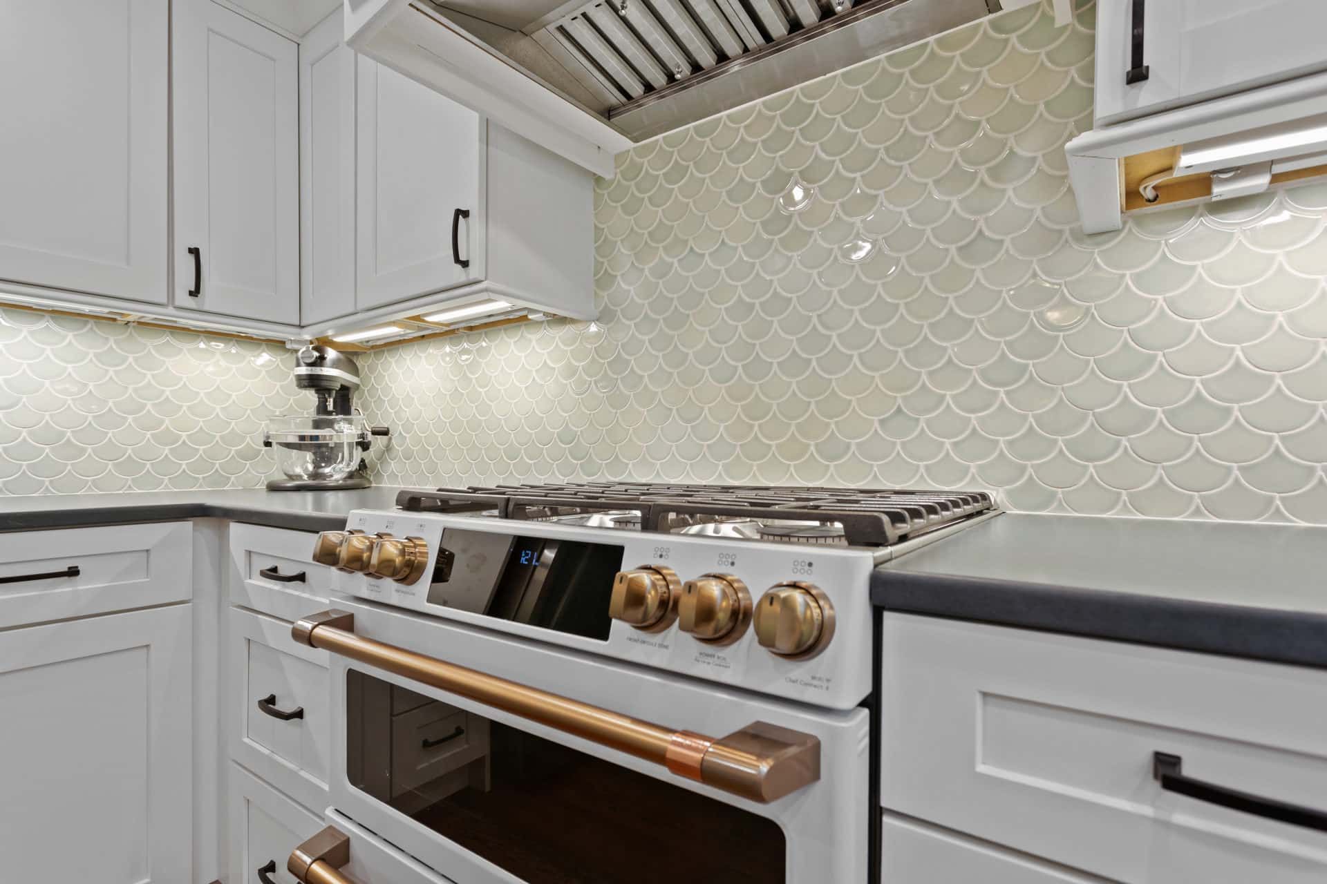 A kitchen with white cabinets and a white stove top oven.