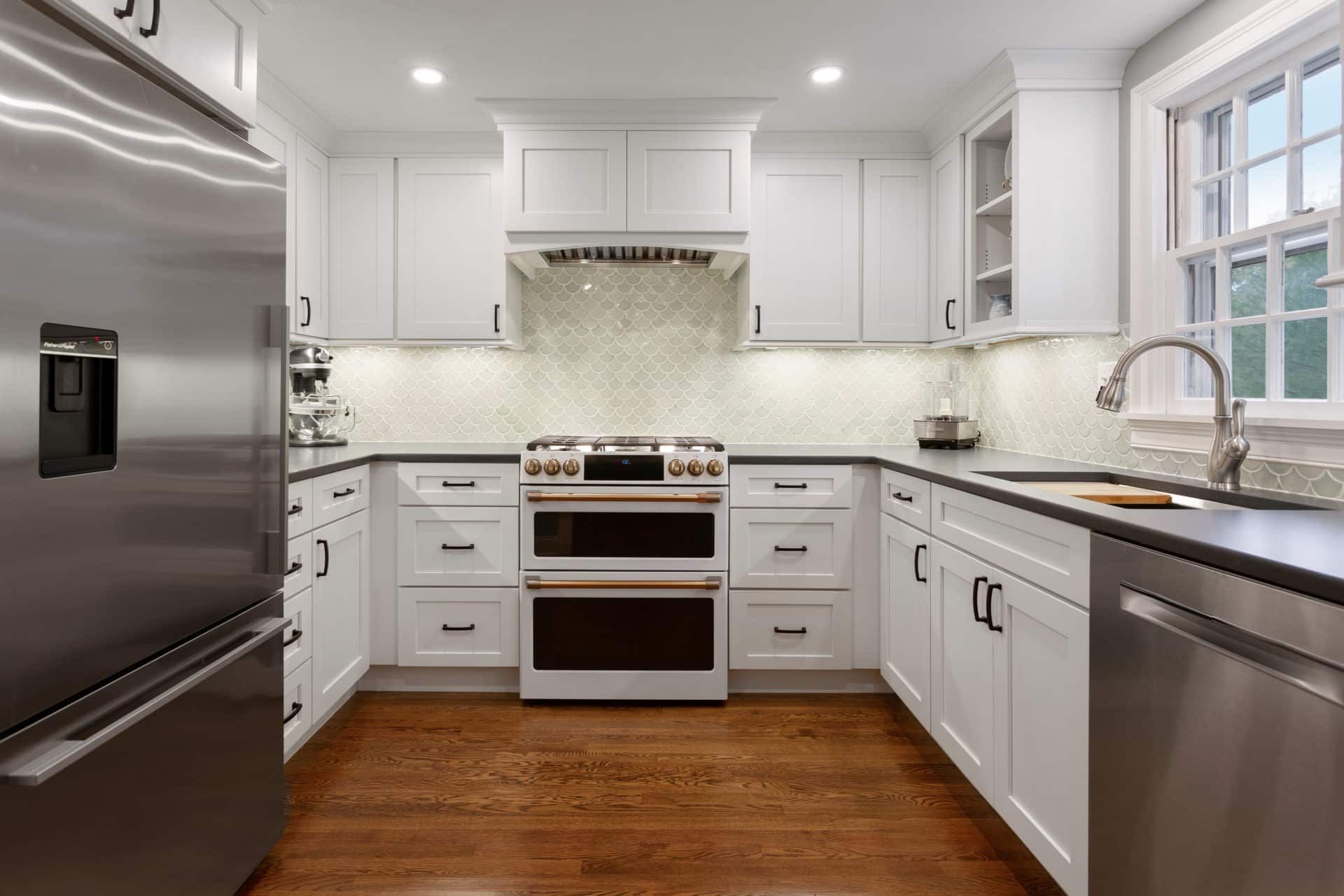 A kitchen with white cabinets and stainless steel appliances.