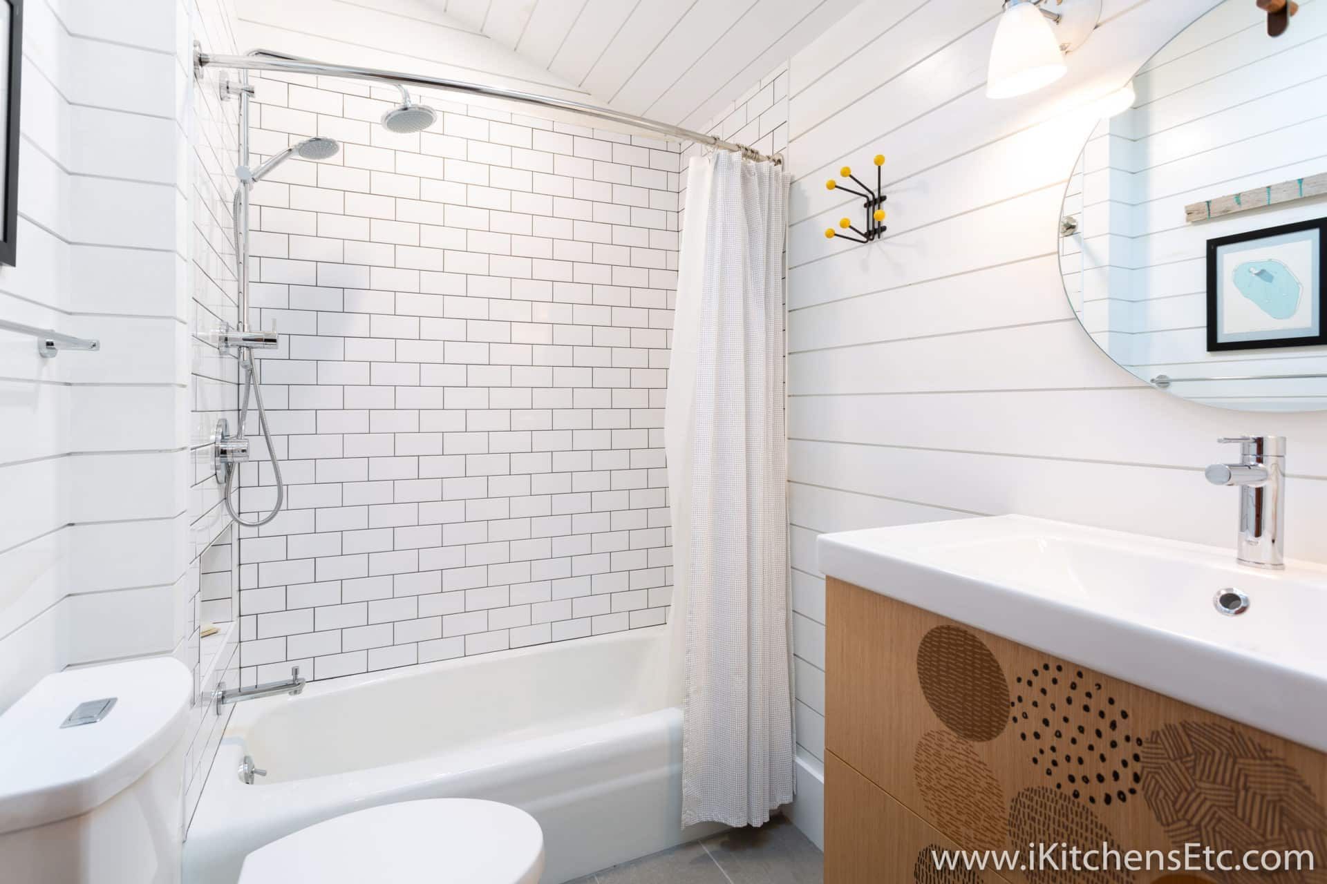 A bathroom with a sink, toilet, shower and mirror.