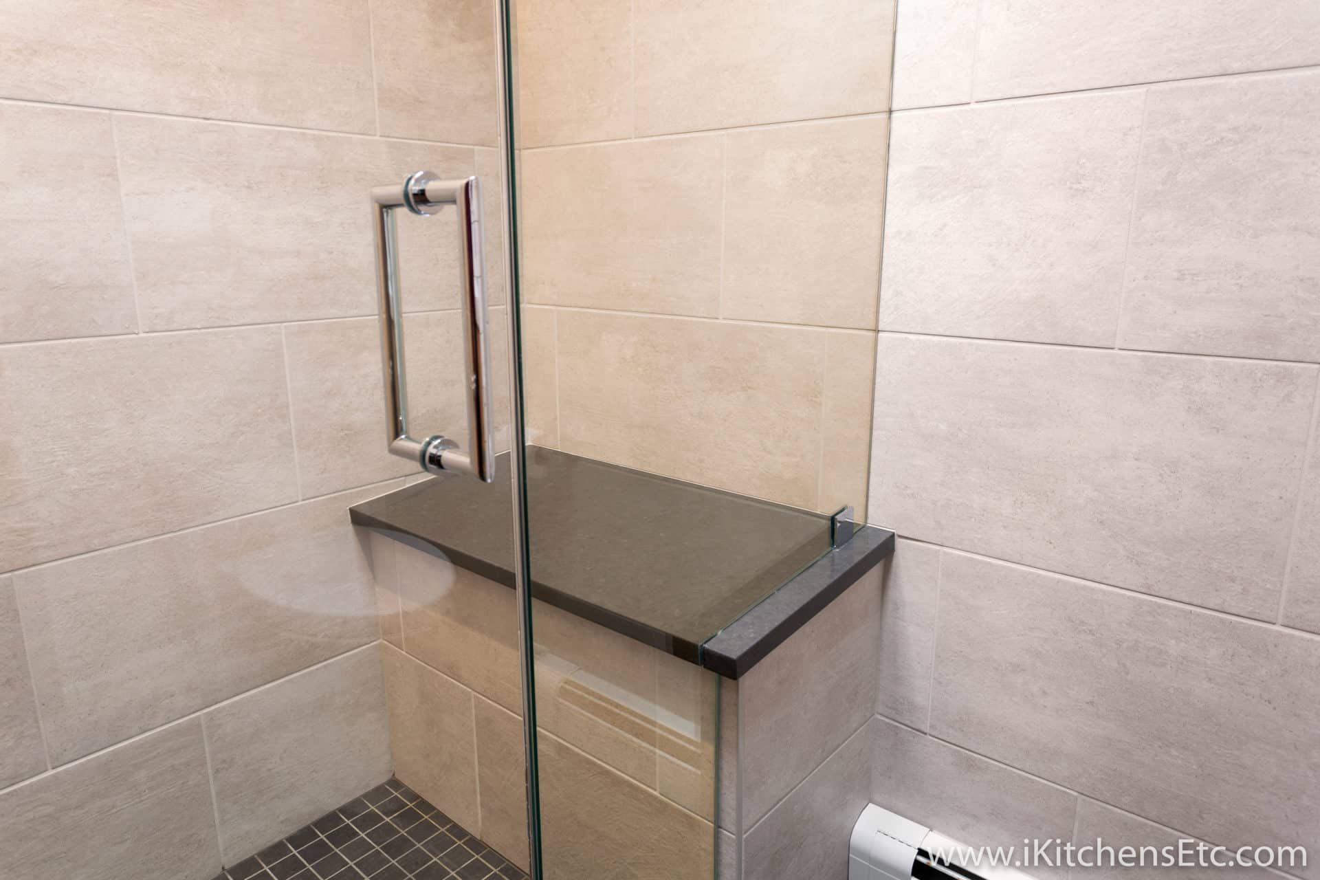 A bathroom with a walk in shower with a glass door
