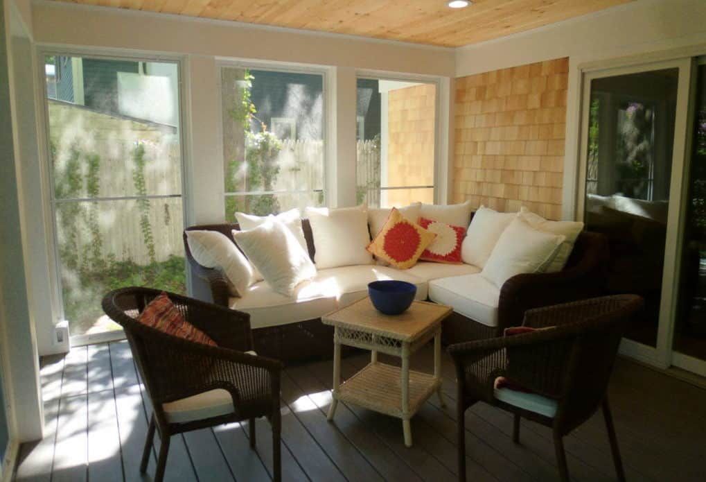 A screened in porch with a couch and chairs