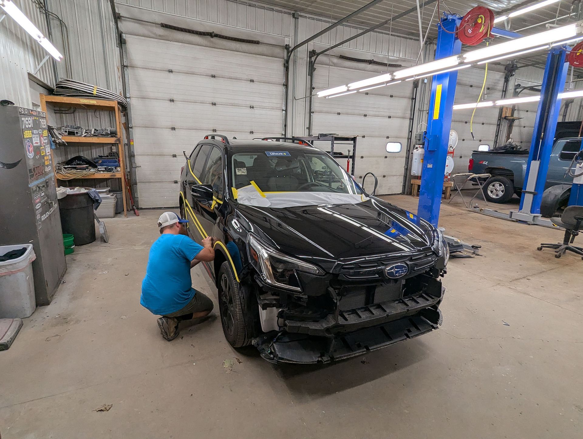 A car is parked in a garage with the doors open.