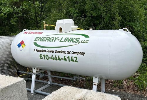 White propane tank labeled “ENERGY-LINKS, LLC” with phone number, mounted outdoors