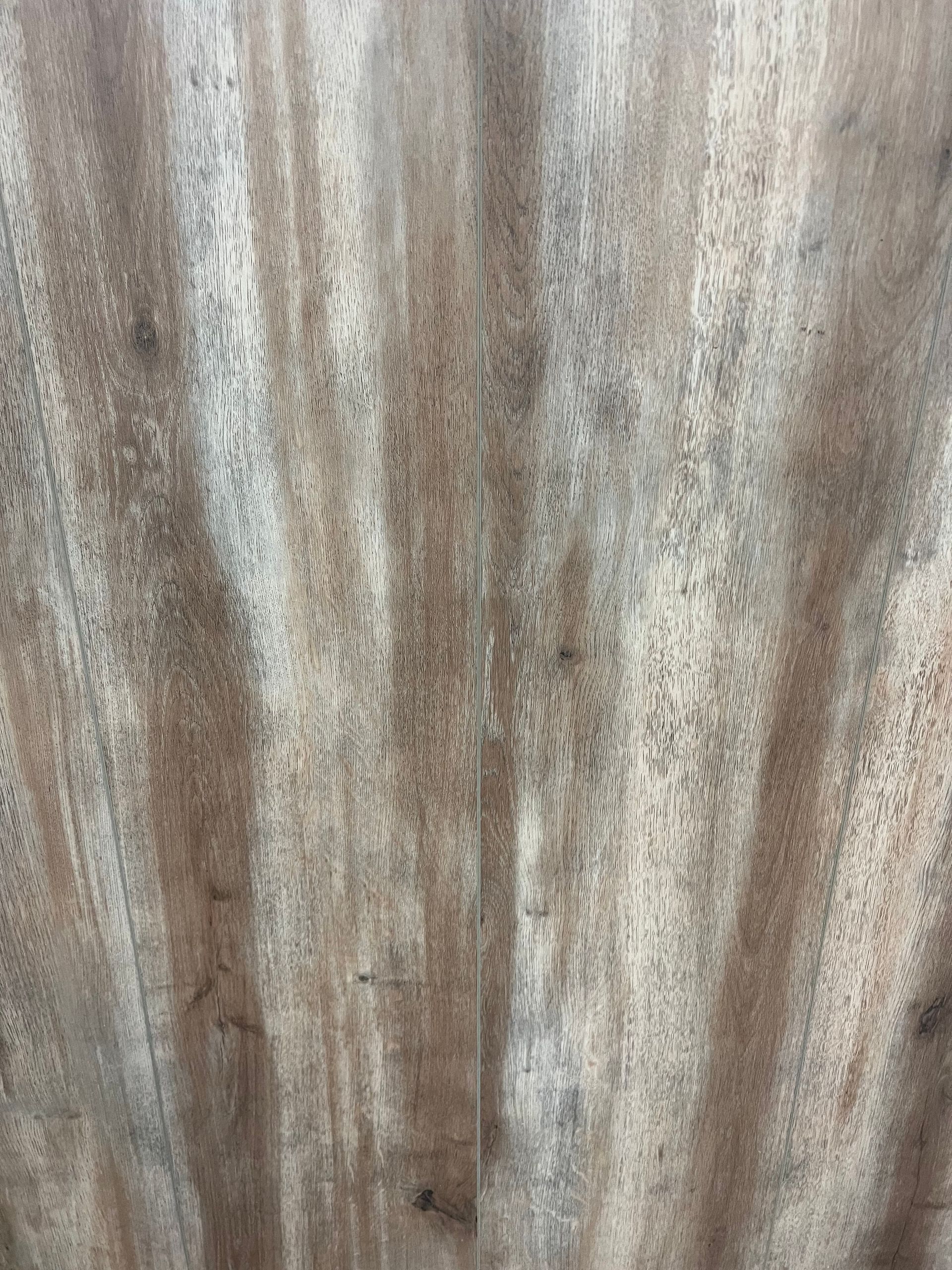 A close-up view of two light brown wood-grain planks joined together, showing a natural vertical pattern and texture.